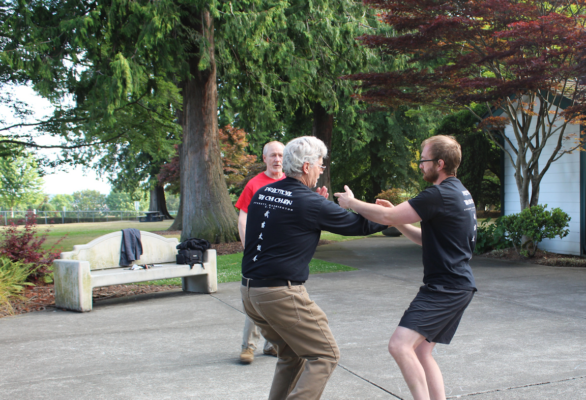Pushing hands practice in Everett, matching Practical Tai Chi shirts